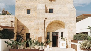 A stone building with a central archway and a small window. - Masseria Corsano (Nardò)