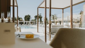 A dining area with a view of a pool and outdoor seating. - Masseria Corsano (Nardò)