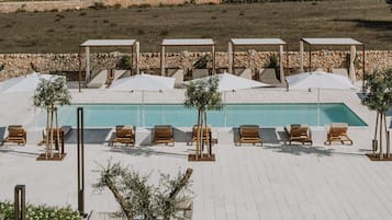 Una piscina al aire libre de temporada, sillones reclinables de piscina