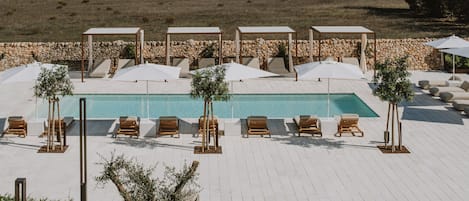 Una piscina al aire libre de temporada, sillones reclinables de piscina