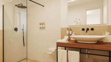 A modern bathroom with a glass shower enclosure, a large sink, and toiletries on the vanity.