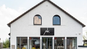 A white building with a black sign reading "AK Allen Keapler". - Smart Bnb - Hotel Battice (Herve)