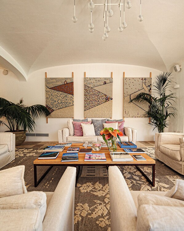 A spacious living room with a large coffee table, comfortable seating, and decorative wall art.