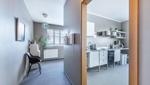 Una cocina moderna con armarios blancos, electrodomésticos de acero inoxidable y un ventanal que proporciona luz natural.