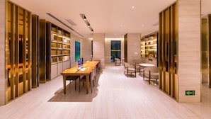 A modern interior with a long wooden table, chairs, and bookshelves. - Ji Hotel (xi'an Giant Wild Goose Pagoda East Xiaoz (Xi'an)