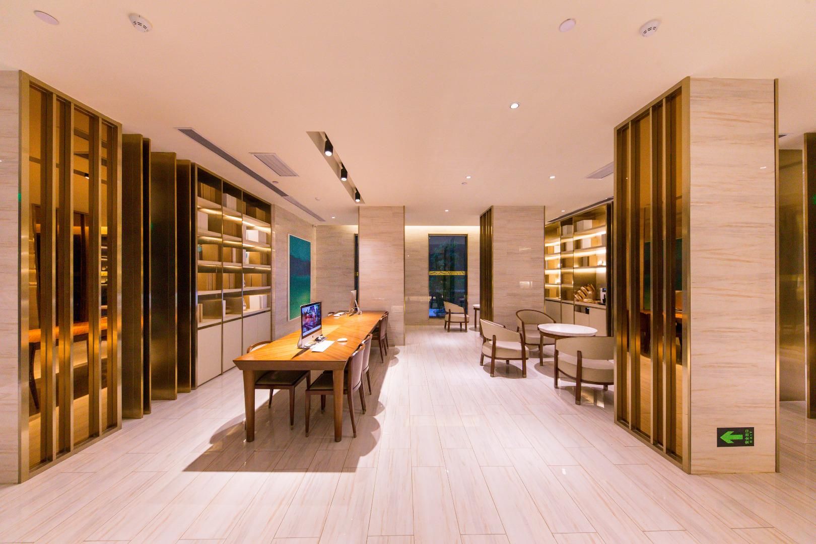 Un interior moderno con una larga mesa de madera, sillas y estanterías.