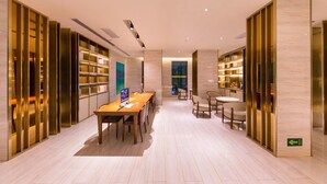 A modern interior with a long wooden table, chairs, and bookshelves. - Ji Hotel (xi'an Giant Wild Goose Pagoda East Xiaoz (Xi'an)