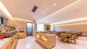 A modern hotel dining area with a central island, seating arrangements, and a view through a glass door. - Ji Hotel (xi'an Giant Wild Goose Pagoda East Xiaoz (Xi'an)