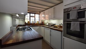 A modern kitchen with a central island, stainless steel appliances, and white cabinetry.