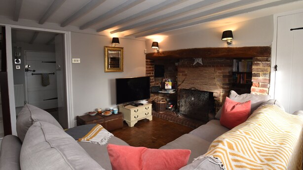 A cozy living room with a fireplace, a television, and a sofa.