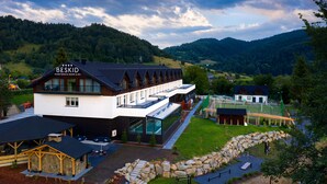 A modern building with a sign reading "BESKID" and a glass facade. - Hotel Beskid Balneo Medical Resort & SPA (Piwniczna-Zdroj)