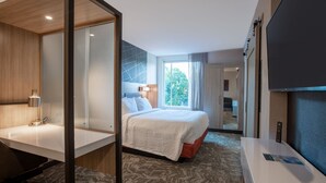A hotel room with a bed, a desk, a TV, and a view of the outdoors. - SpringHill Suites Chester (Chester)