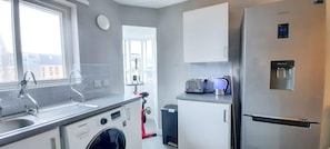 Enjoy cooking in this well-equipped kitchen with a refrigerator, dishwasher, and washing machine.