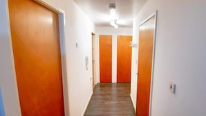 Un pasillo con puertas de madera y un accesorio de iluminación en el techo.