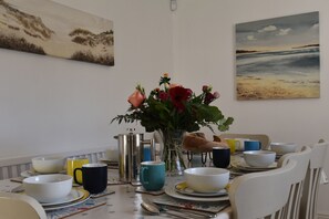 A dining table set with various dishes, cups, and a vase of flowers.