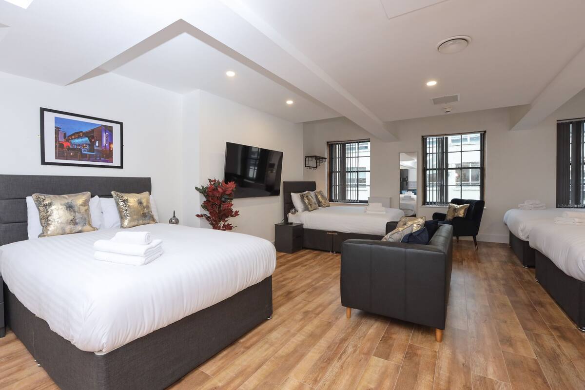Una habitación de hotel moderna con una cama grande, un sofá y una televisión.