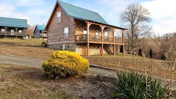 Cozy cabin with a spacious porch and a beautifully maintained lawn.