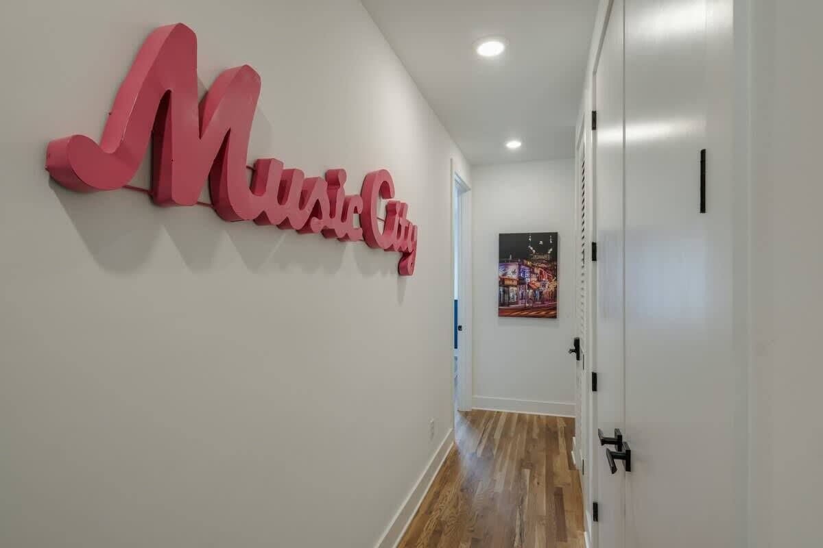 Un couloir orné d’une grande enseigne rose sur le mur, sur laquelle on peut lire : « Music City ».