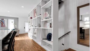 A modern kitchen with white cabinetry, a wooden countertop, and a built-in oven. - Rooftop deck, hot tub & neon game room | Nashville, sleeps 12 (Nashville)