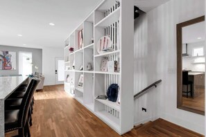Una cocina moderna con armarios blancos, encimera de madera y horno empotrado.