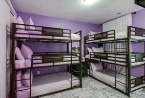 A room with bunk beds, purple walls, and a marble floor.