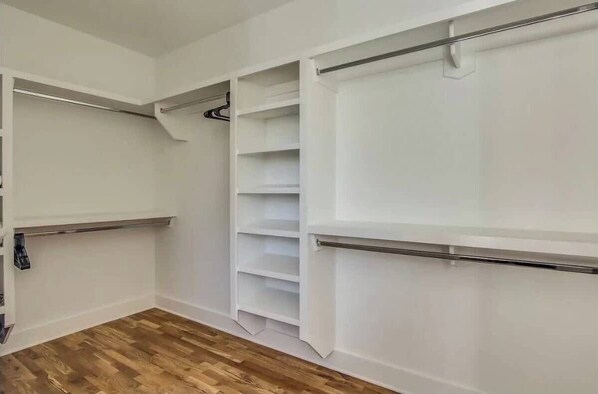 A walk-in closet with open shelving and hanging space. - Nashville 4BR house: rooftop hot tub, wet bar, sleeps 12 (Nashville)