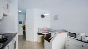 A compact kitchen with a microwave, toaster, and a small dining area with a bench. - Great location!1 bedroom Costa adeje very central (Costa Adeje)