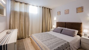 A neatly arranged bedroom with a bed, bedside tables, and curtains. - Great location!1 bedroom Costa adeje very central (Costa Adeje)
