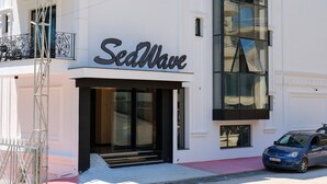 A modern building with a large sign reading "SeaWave." - Seawave Hotel (Sarandë)