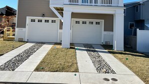 A two-story house with a garage, a balcony, and a well-maintained lawn. - Beautiful Newer Construction 5 BR 3.5 bath (Ocean City)