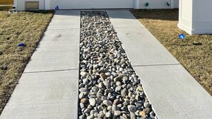 A residential house with a white garage, beige siding, and a concrete pathway with a gravel border. - Beautiful Newer Construction 5 BR 3.5 bath (Ocean City)