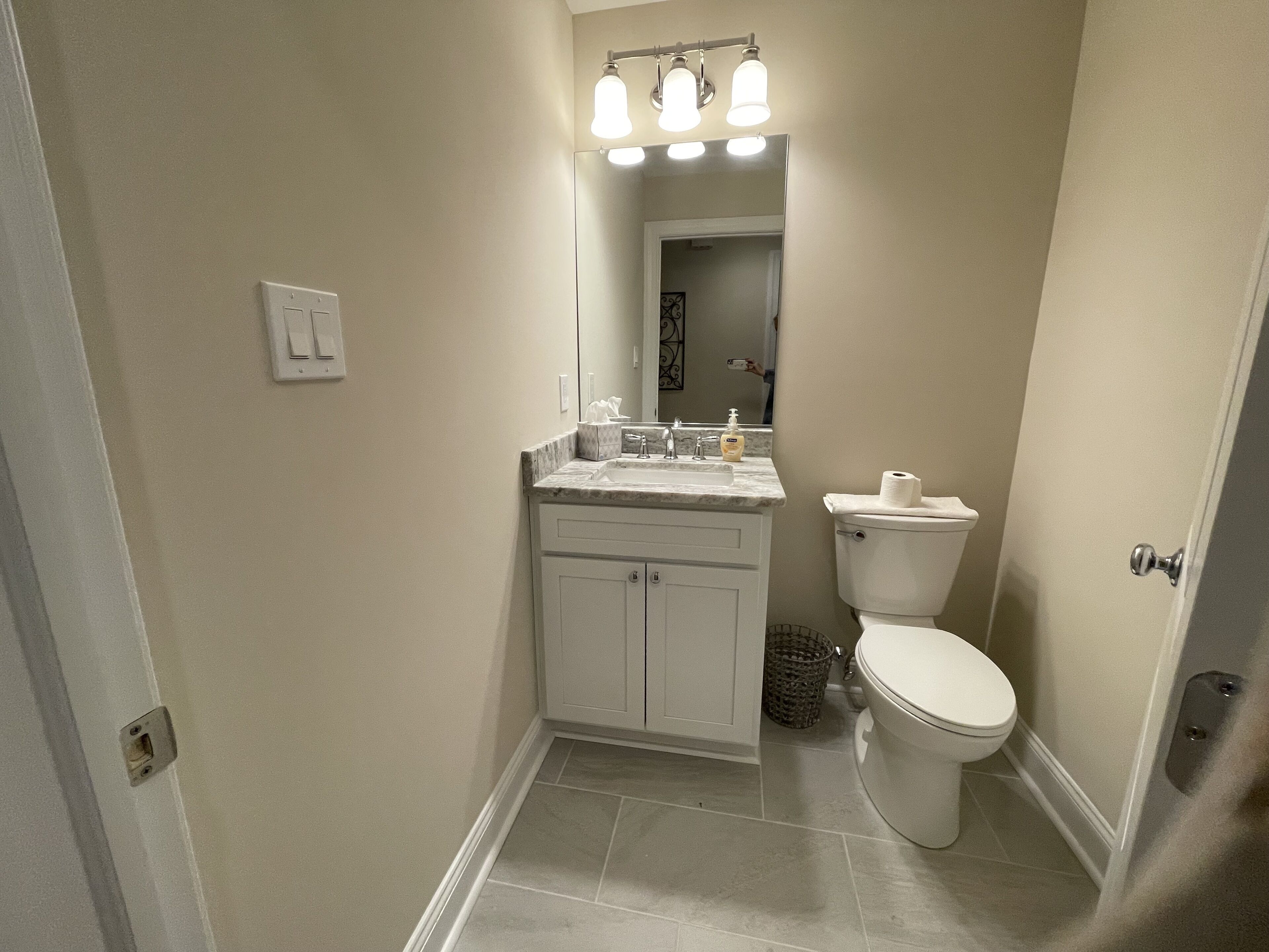 Une salle de bain avec des toilettes, un lavabo et un miroir.