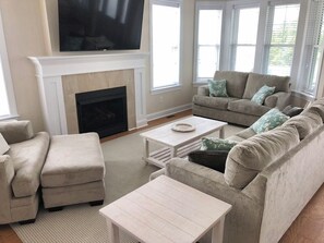 Cozy living room with a fireplace, modern TV, and comfortable seating for relaxation.