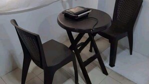 Una stanza piccola con un tavolo rotondo e due sedie.