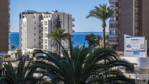 Un hôtel appelé BRISA, offrant une vue sur la mer, des palmiers et un paysage urbain en arrière-plan.