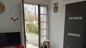 A room with a desk, chair, and a door leading outside. - Maison ds Marais Poitevin (Taugon)