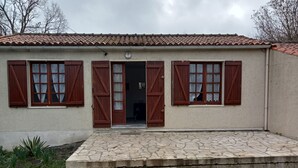 A building with a tiled roof, a stone-paved entrance, and wooden shutters on the windows. - Maison ds Marais Poitevin (Taugon)