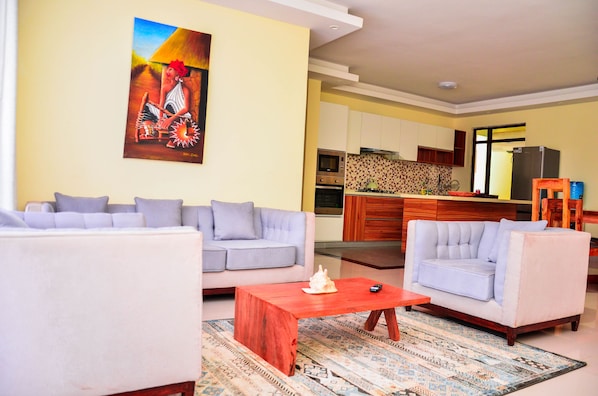 A living room with a sofa, a coffee table, and a painting on the wall.