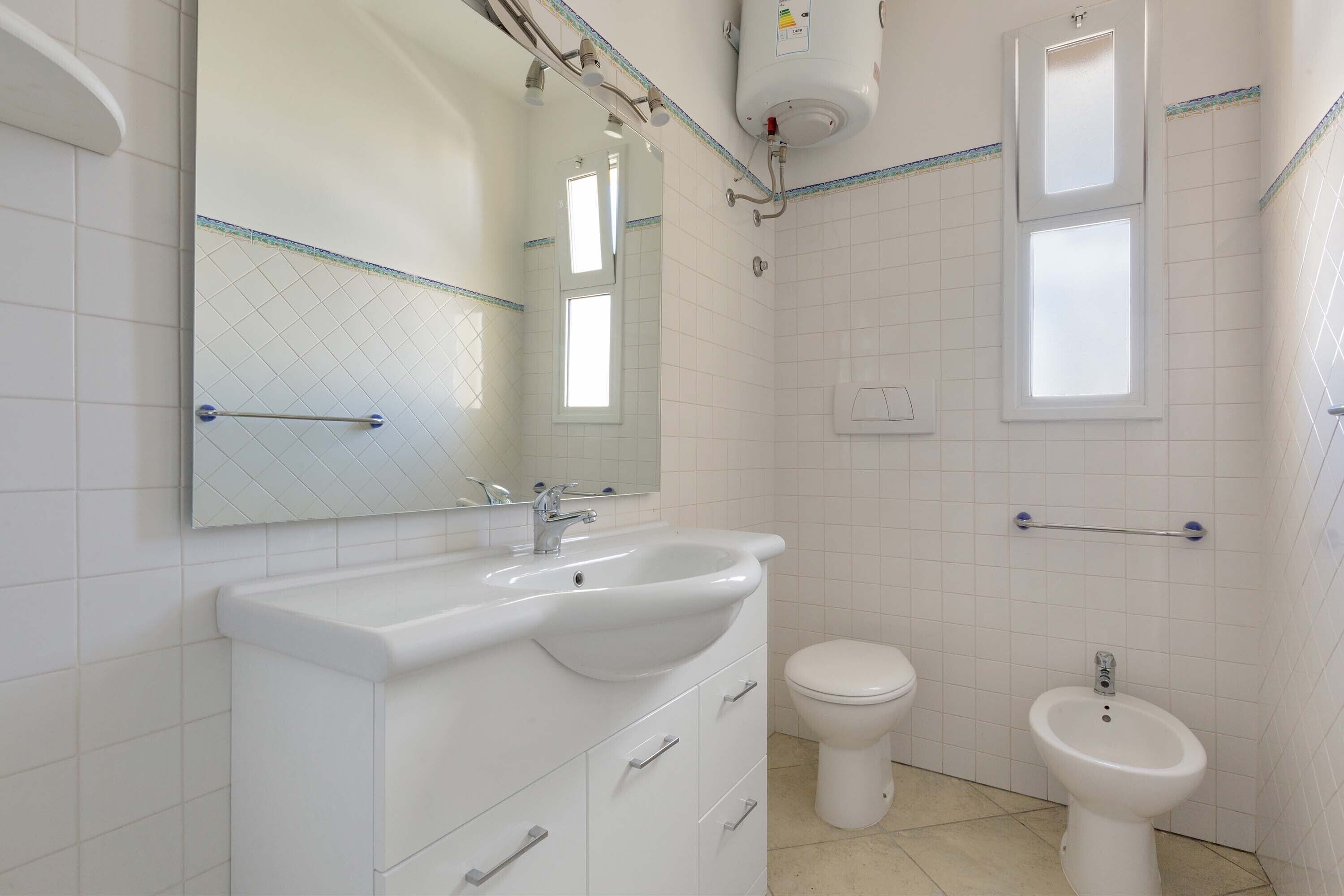 Un baño con lavamanos blanco, inodoro y bidé.