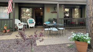 A patio with outdoor furniture, a flag, and a small tree. - Sports Village Lower Unit Comfy Mountain Retreat (Pinetop)
