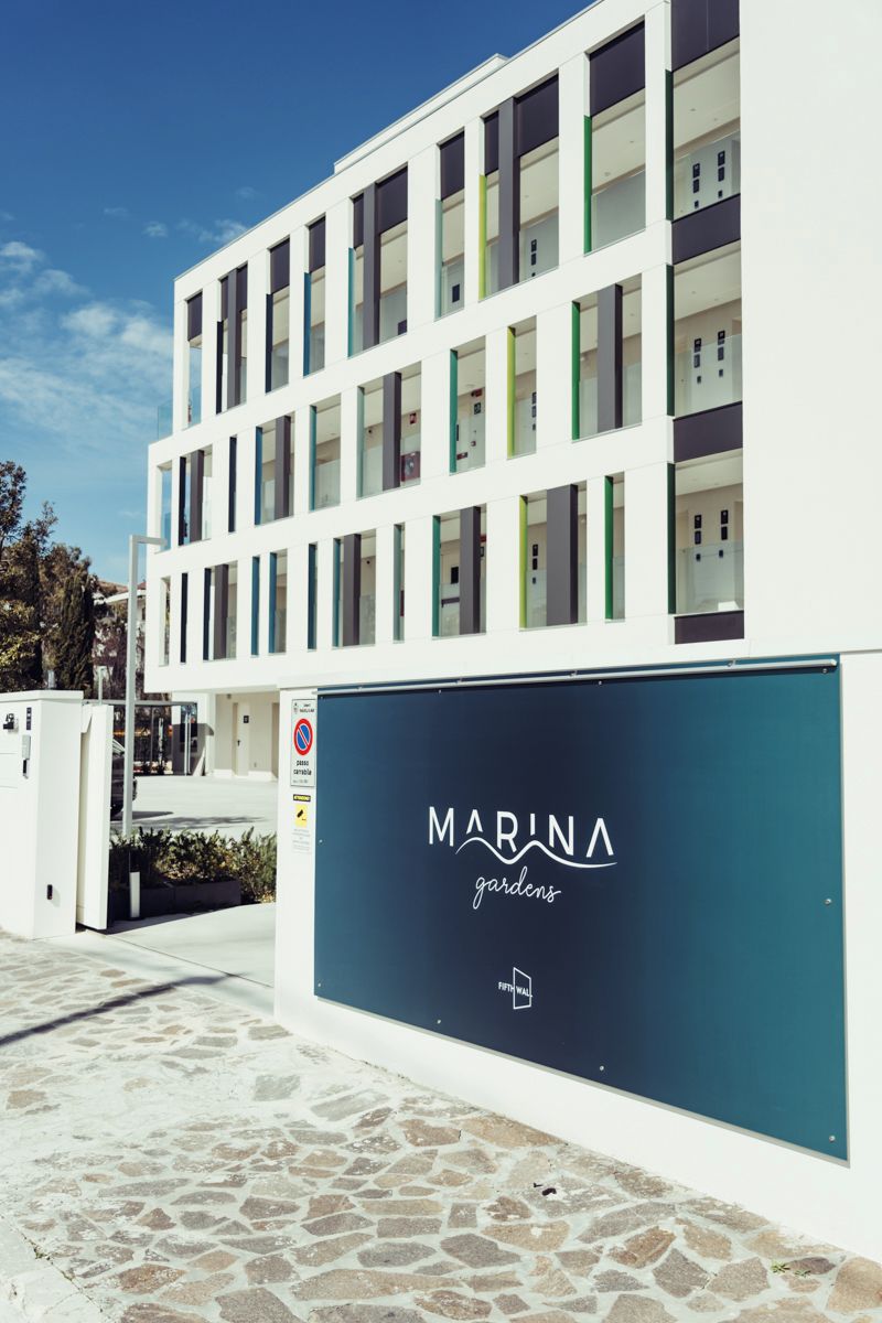 A modern building with a sign that reads "MARINA gardens".