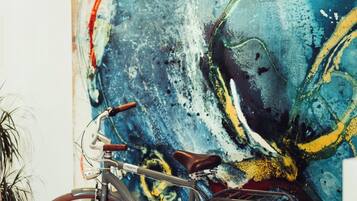 A bicycle parked in front of a large abstract painting.