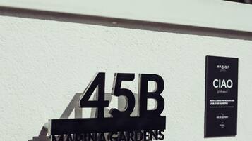 A building with a sign reading '45B MARINAGARDENS' and a security panel with a 'CIOFONO' label.