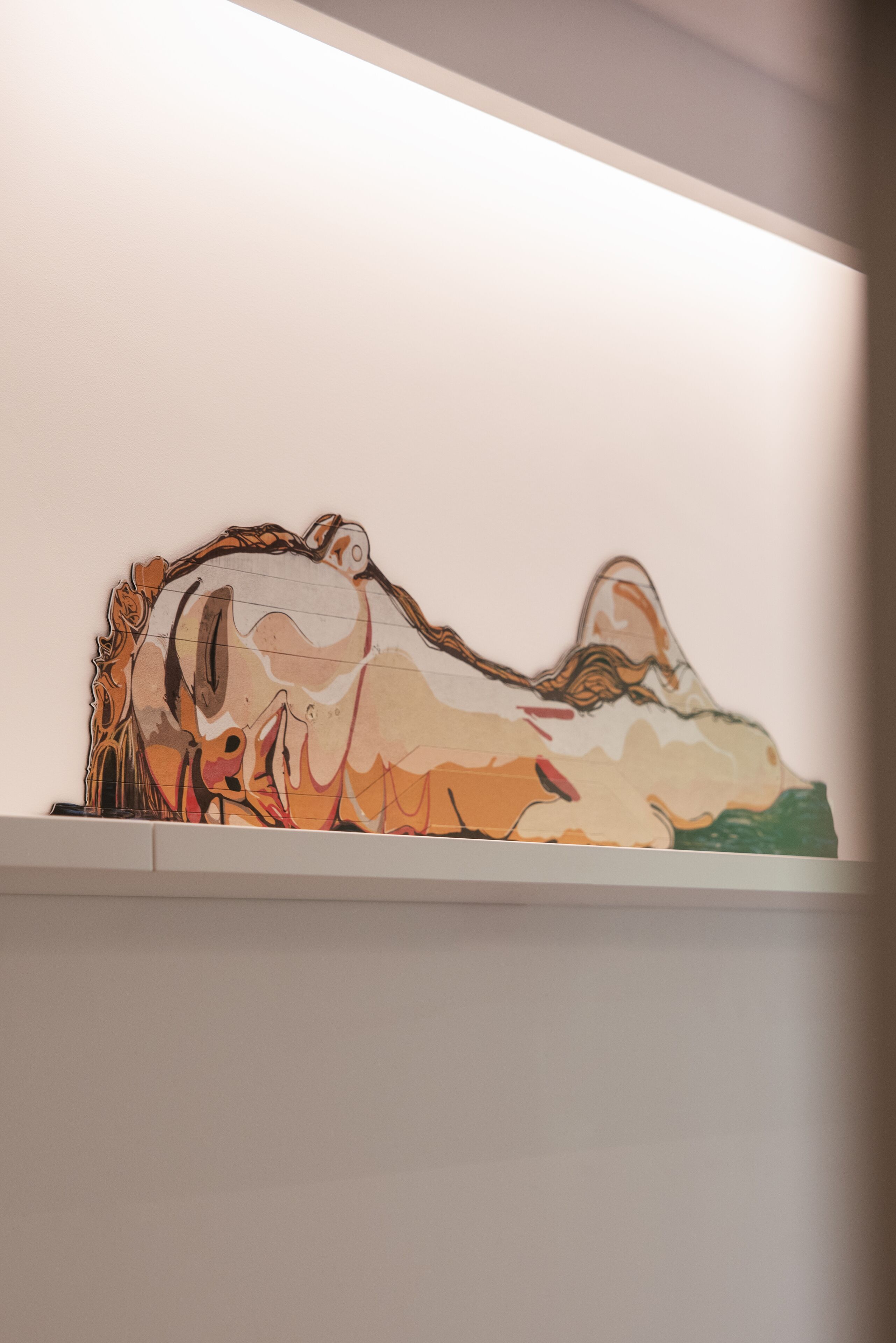A wall-mounted artwork depicting a stylized animal figure.