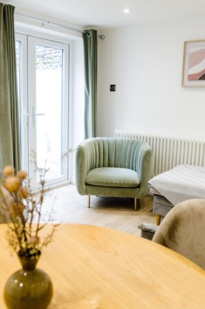 Un salon moderne avec un canapé, un radiateur et une fenêtre avec des rideaux.