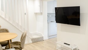 Een modern interieur met een eethoek, een keuken en een wandtelevisie.