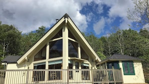 A two-story building with a prominent triangular roof, large windows, and a wooden deck. - 2 bedroom accommodation in Linlithgow, near Edinburgh (Linlithgow, near Edinburgh)
