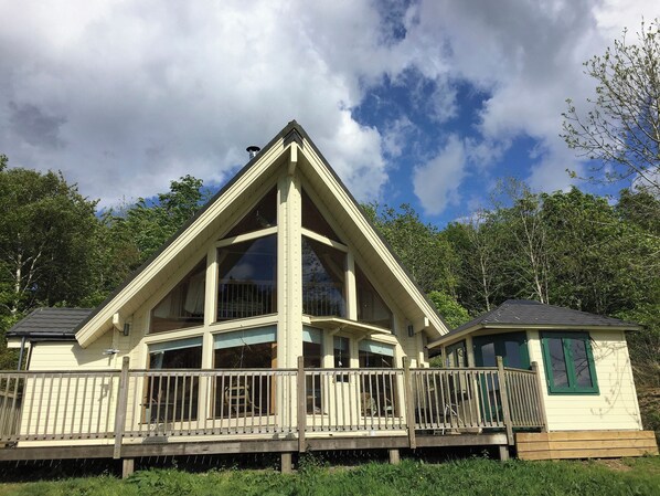 A two-story building with a prominent triangular roof, large windows, and a wooden deck. - 2 bedroom accommodation in Linlithgow, near Edinburgh (Linlithgow, near Edinburgh)