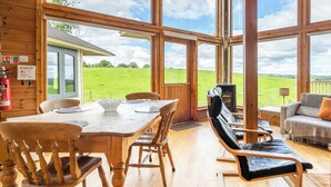 A wooden interior with a dining table, chairs, a sofa, and a TV. - 2 bedroom accommodation in Linlithgow, near Edinburgh (Linlithgow, near Edinburgh)
