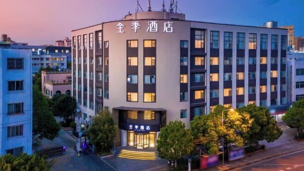 A multi-story hotel with a modern facade, a prominent entrance, and a well-lit exterior.